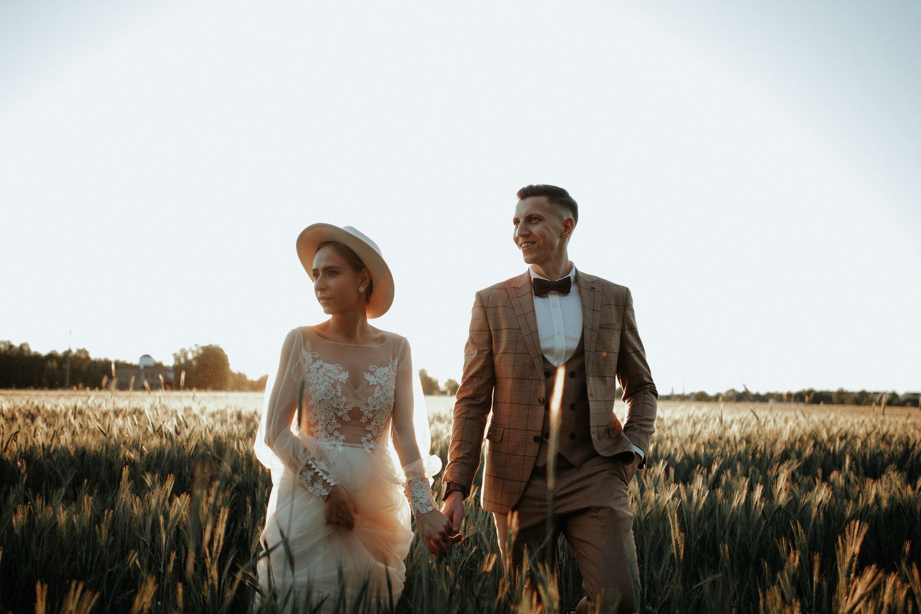 Couple walking through the fields at sunset